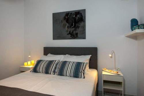 una camera da letto con un letto con un dipinto bianco e nero sul muro di Easy Living City Apartment a Chania
