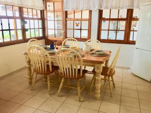 een eettafel met 4 stoelen en een tafel en een koelkast bij Spacious characterful villa with spectacular views in quiet rural setting. in Breña Alta