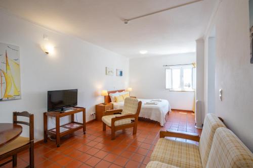 a living room with a bed and a television at Apartamentos Atlantico by Umbral in Vila Nova de Milfontes