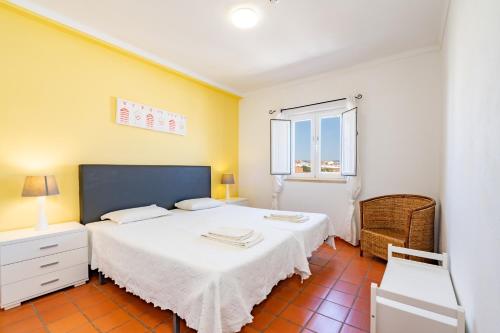 a bedroom with a white bed and a window at Apartamentos Atlantico by Umbral in Vila Nova de Milfontes