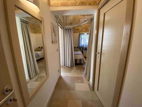 un couloir avec un grand miroir et une chambre dans l'établissement VERDEACQUA HOUSE, à Locorotondo