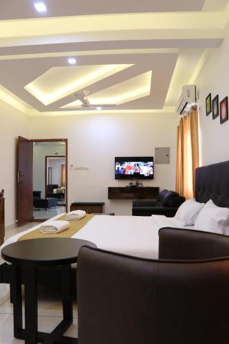 a bedroom with a bed and a tv on the wall at Dana Residency by D2v in Ernakulam