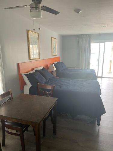 a hotel room with two beds and a table at Ships Inn in Hampton