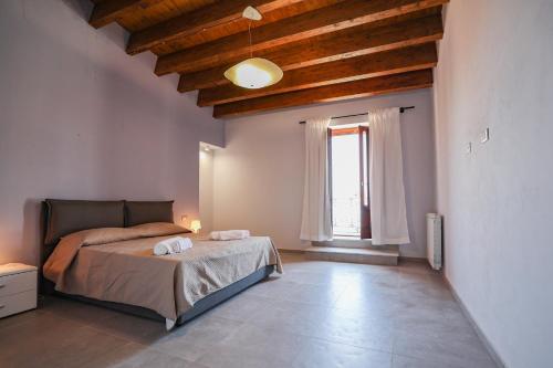 a bedroom with a bed and a large window at Le Signorine Panoramic apartments in Gratteri