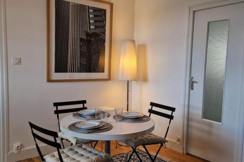einen Esstisch mit 4 Stühlen, einem weißen Tisch und einem Stuhl in der Unterkunft Au cœur des remparts in Vannes