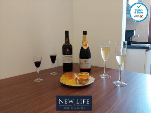 - une table avec 2 bouteilles et 2 verres de vin dans l'établissement New Life - PARQUE CIDADE STUDIO-0T, à Porto