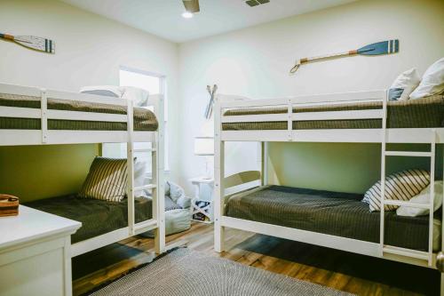 パドレ・アイランドにあるCasa Pura Vidaの二段ベッド3台と机のある部屋