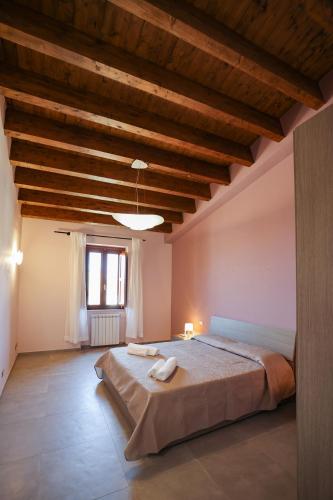 a bedroom with a large bed with a wooden ceiling at Le Signorine Panoramic apartments in Gratteri