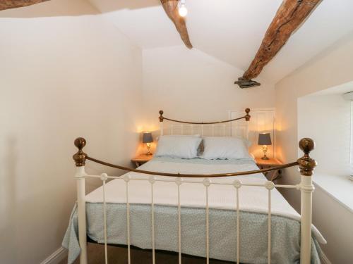 a bedroom with a white bed with two lamps at The Annexe in Soutergate