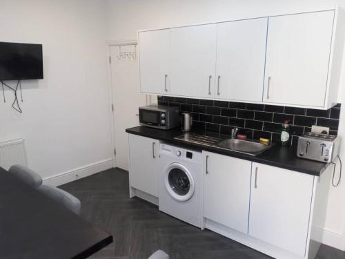 een keuken met een wastafel en een wasmachine bij Ensuite Double-bed (E3) close to Burnley city centre in Burnley