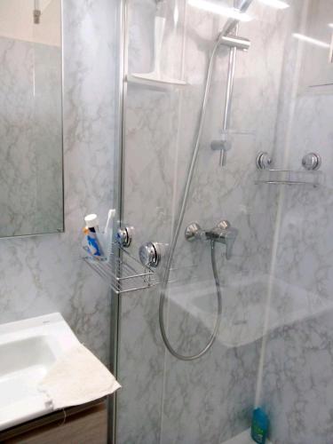 une douche dans une salle de bain avec une porte de douche en verre dans l'établissement Port panoramique, à Gruissan