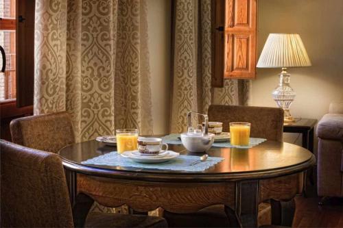 una mesa de comedor con vasos de zumo de naranja. en Palace suite apartment, en Toledo