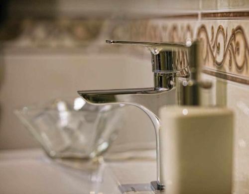 a bathroom sink with a faucet and a glass bowl at Palace suite apartment by Toledo AP in Toledo