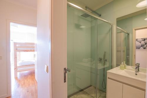 y baño con ducha acristalada y lavamanos. en Portugal Active Moledo Beach House, en Moledo