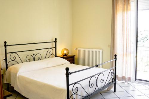 1 dormitorio con cama y ventana en Locanda Le Tre Sorelle, en Casal Velino