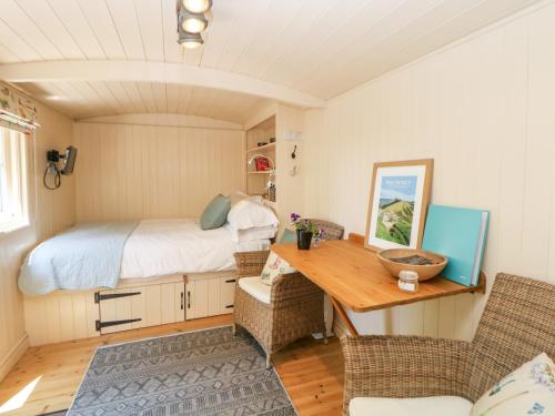 a small room with a bed and a desk at Shepherd's Hut in Castleton