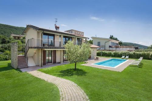 a house with a swimming pool in a yard at Cà Bosca - Fine Living in Torri del Benaco