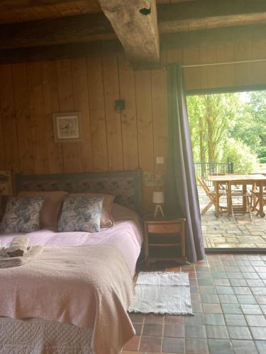 1 dormitorio con 2 camas y patio con mesa en la garçonnière, en Nivillac