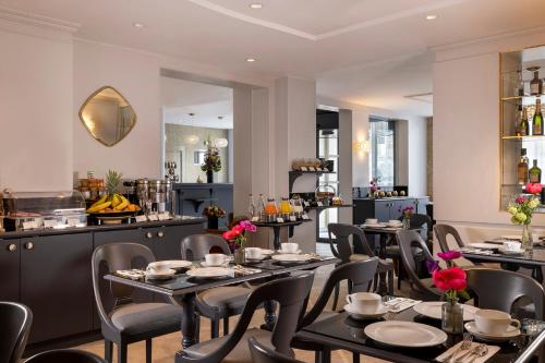 un restaurant avec des tables et des chaises ainsi qu'un bar dans l'établissement Hôtel Madeleine Plaza, à Paris