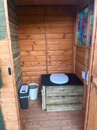 una sauna con aseo y cubo de basura en Belle Village, non electric ,Rent a bell tent, BEDDING NOT SUPPLIED, en Narberth