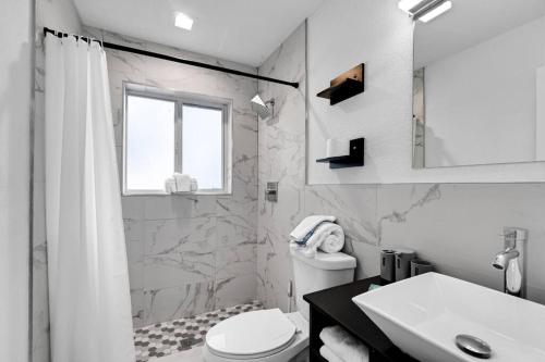 La salle de bains blanche est pourvue d'un lavabo et de toilettes. dans l'établissement Vacation Home 3 Bedrooms, Private Pool and Pool Table, à Fort Lauderdale