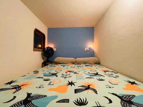 1 dormitorio con 1 cama con un edredón colorido en Hospedagem Sabor Da Trilha en Vale do Capao
