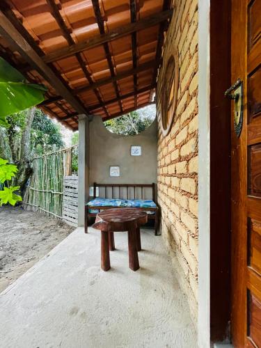 a patio with a table and a bench on a porch at Hospedagem Sabor Da Trilha in Vale do Capao