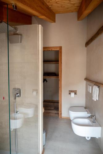 a bathroom with two sinks and a toilet and a shower at Residenza dell'Aquila - appartamento in Vezza dʼOglio