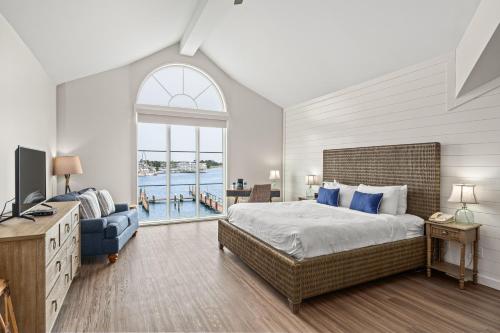 a bedroom with a bed and a tv and a window at St Michaels Harbour Inn, Marina and Spa in Saint Michaels