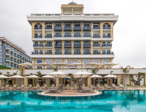 um hotel com piscina e um edifício em Serenity Queen Hotel em Alanya