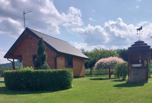 a small house with a bush in front of it at Domki wypoczynkowe - całoroczne. in Wysowa-Zdrój