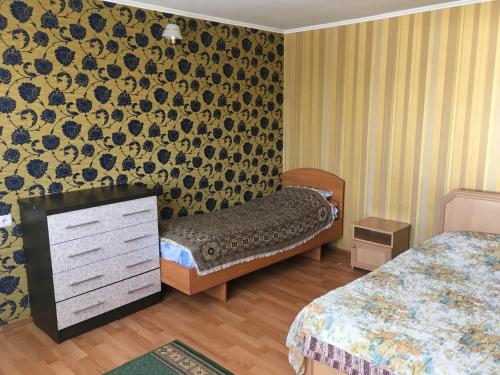 a hotel room with two beds and a dresser in it at Эдем in Cholpon-Ata