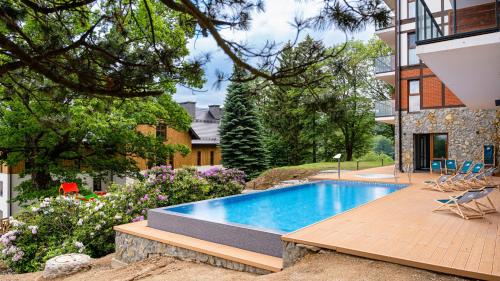 a swimming pool in a yard next to a building at Apartament N&B in Szklarska Poręba