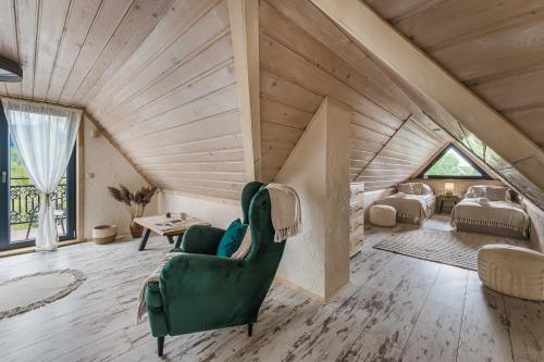 a room with a green chair in a attic at Willa Skała in Kościelisko