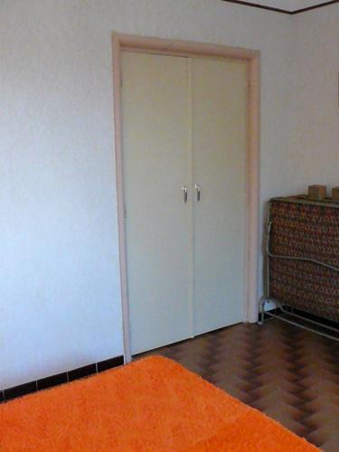 une pièce vide avec une porte avec un tapis orange dans l'établissement Location (1bis) dans un Mas avec piscine et parking, à Argelès-sur-Mer