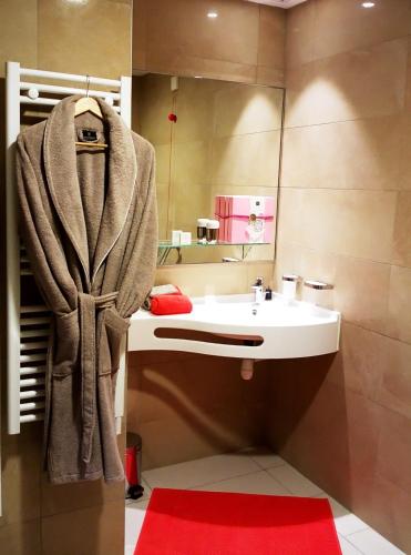 une salle de bain avec un lavabo et un miroir dans l'établissement Uzès Appart'S, à Uzès