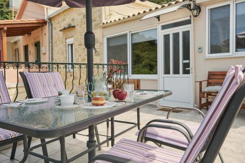 a table and chairs on a patio with an umbrella at Batilas Garden House in Kissamos