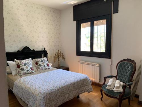 - une chambre avec un lit, une chaise et une fenêtre dans l'établissement Casa Rural Humberto con 3 dormitorios, à Malaga