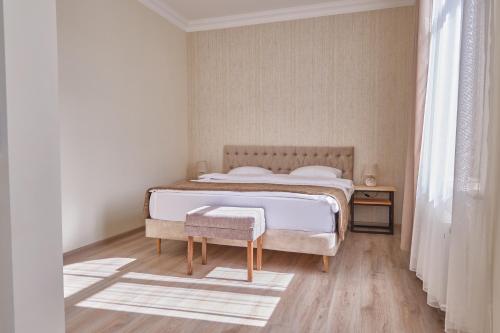 biała sypialnia z łóżkiem i drewnianą podłogą w obiekcie 21 Rooms Hotel w mieście Giumri