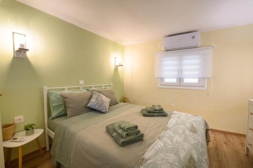 1 dormitorio con cama y ventana con aperitivo en The Corfiot ' city center ' en Corfú