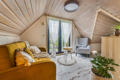 a living room with a yellow couch and a chair at Willa Skała in Kościelisko