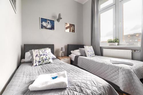 a bedroom with two beds and a window at Stawa Villa & Apart in Świnoujście