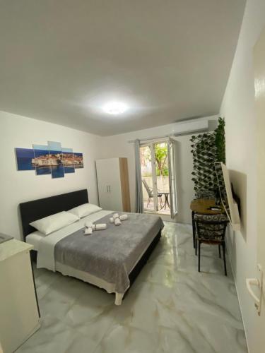 a bedroom with a bed and a table and a window at King's Landing Esma' house in Dubrovnik