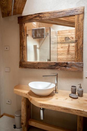 a bathroom with a white bowl sink on a wooden counter at Residenza dell'Aquila - appartamento in Vezza dʼOglio