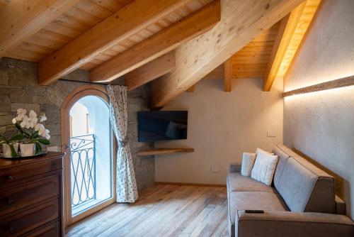 a living room with a couch and a large window at Residenza dell'Aquila - appartamento in Vezza dʼOglio