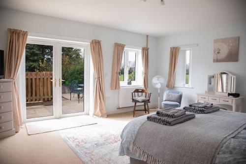a bedroom with a large bed and a balcony at Cygnets Nest in Worstead