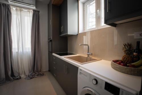 a kitchen with a sink and a washing machine at Aggire Zante Luxury Residence in Zakynthos