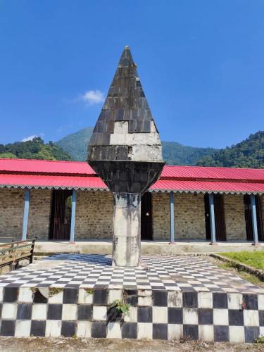 a statue in front of a building with a checkered at DOOARS VELLEY HOME STAY in Buxa Duār