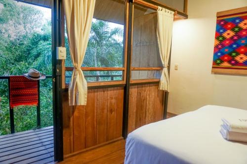 a bedroom with a bed and a large window at Pacha Eco Lodge Glamping & Hotel in Archidona