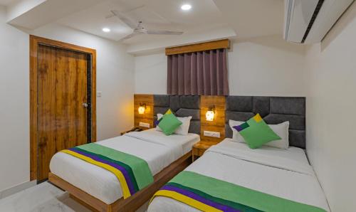 a bedroom with two beds and a window at Treebo Prince Plaza in Ahmedabad